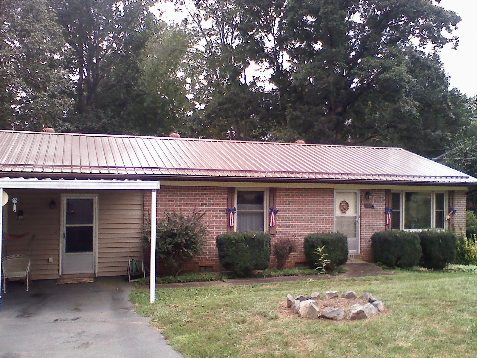 Bronze metal roof and carport on a brick ranch home — Roof Repair work by our crew in Ottawa