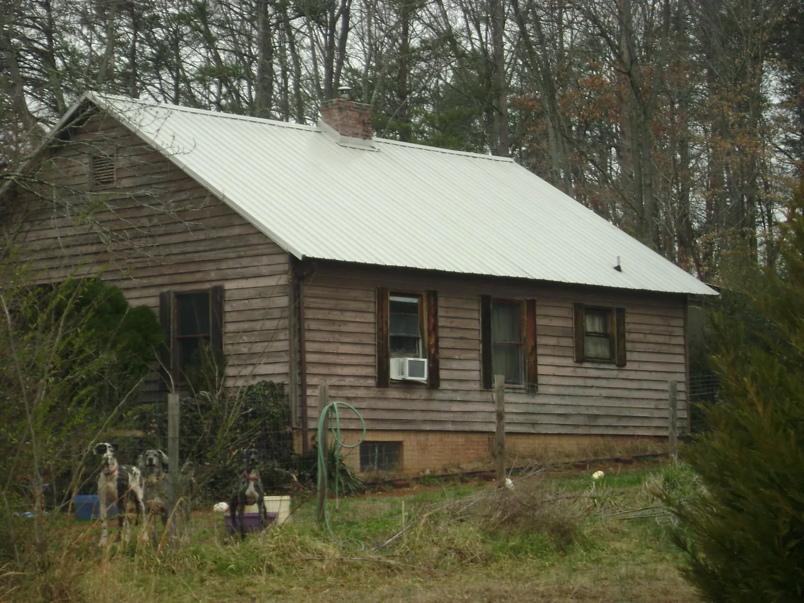 White metal roof on an old wood sided farmhouse, from a Metal Roof Installation job in Ottawa